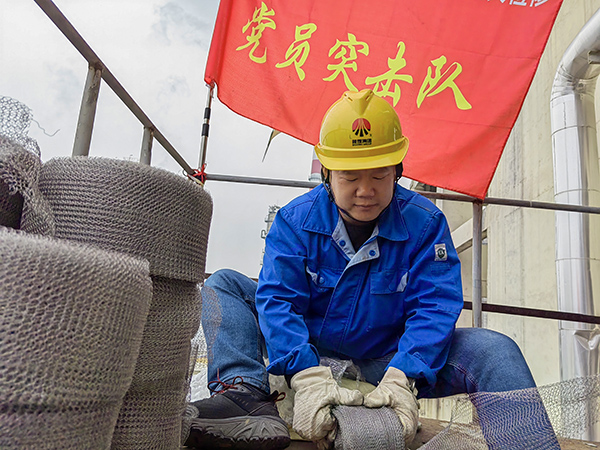 5月10日中午，在動力車間三期工藝除氧器平臺上，黨員突擊隊隊長李鑫正在纏繞新填料.jpg