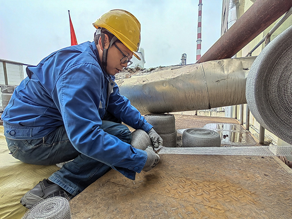5月10日中午，在動力車間三期工藝除氧器平臺上，黨員突擊隊隊員劉瑞斌正在纏繞新填料.jpg