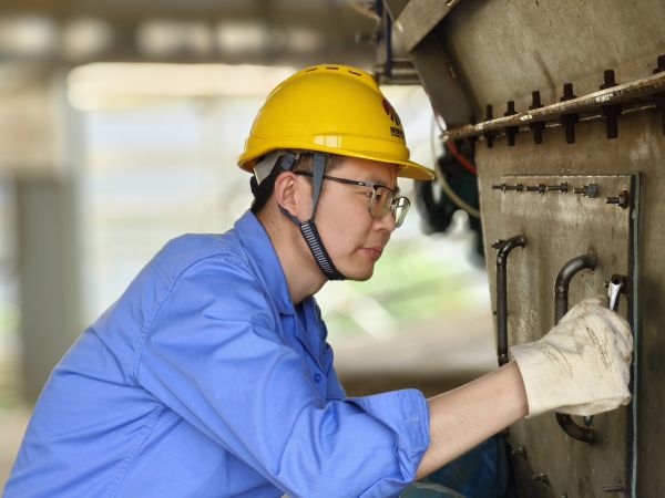 5月11日，尿素車間設(shè)備技術(shù)員馬強(qiáng)檢查設(shè)備螺栓是否松動(dòng).jpg